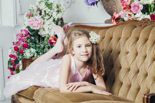 Portrait of a little girl lying on the couch - Фото, изображение