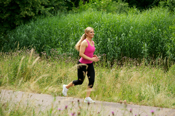 Healthy young woman exercising outdoors - Fotografie, Obrázek