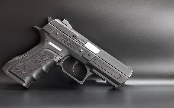 Черный пистолет 9 мм на сером фоне
 - Фото, изображение