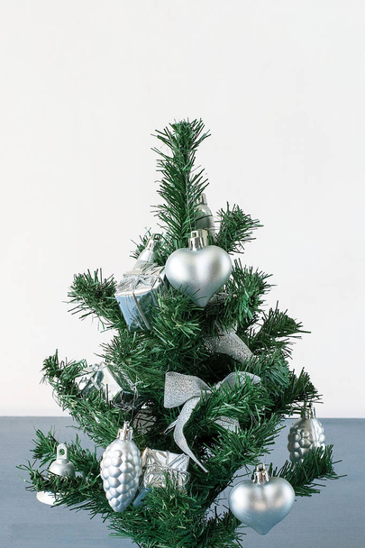 Концепция "С Новым годом и Рождеством", маленькая елка, украшенная рождественскими украшениями
 - Фото, изображение