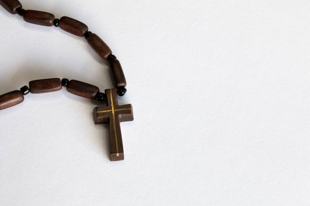 Croce in legno con catena su sfondo bianco
 - Foto, immagini