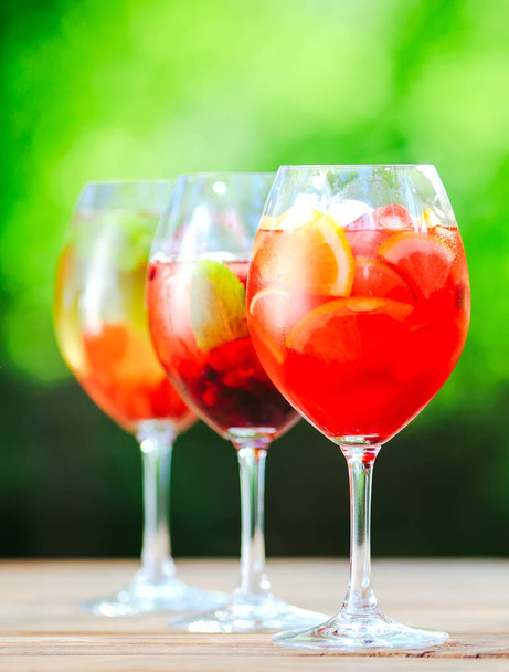 Summer cocktail. Fruit cocktail on green background. Citrus fruits, berries, strawberries, blueberries, mint, ice - Fotoğraf, Görsel
