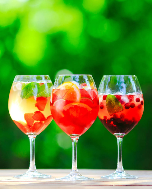 Summer cocktail. Fruit cocktail on green background. Citrus fruits, berries, strawberries, blueberries, mint, ice - Fotoğraf, Görsel