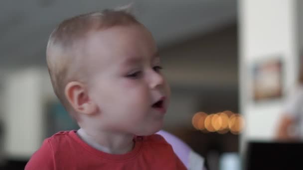 Küçük çocuk komik yavaş çekimde bir mama sandalyede otururken başını döner - Video, Çekim