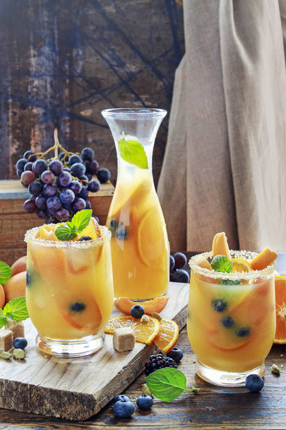 Summer drink with peaches, oranges and blueberries.  - Photo, image