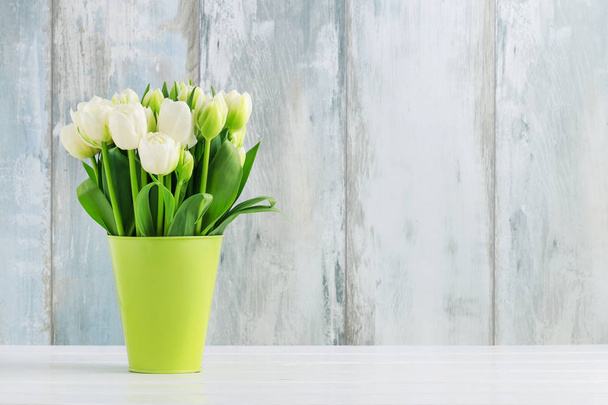 Bouquet of tulips in green bucket. - Фото, зображення