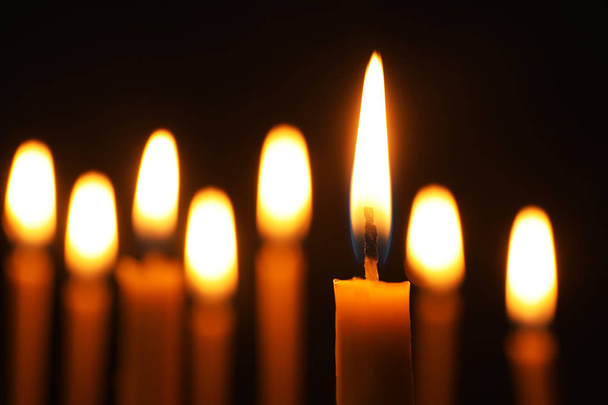 Burning candles on dark background, space for text. Symbol of sorrow - 写真・画像
