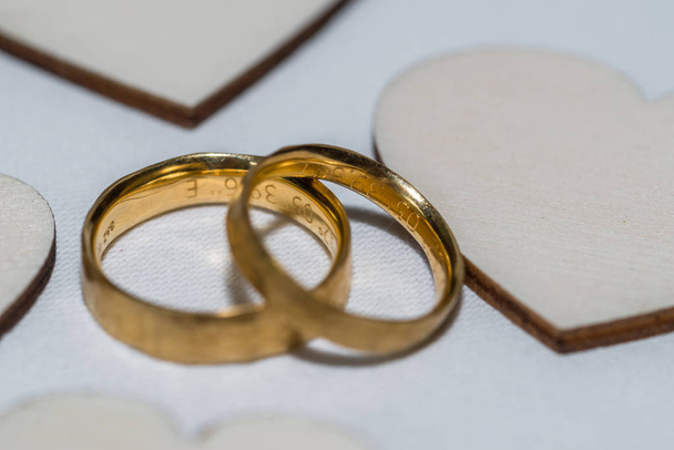 Χρυσά δαχτυλίδια γάμου σε ένα τραπέζι με καρδιές από ξύλο, Γερμανία - Φωτογραφία, εικόνα