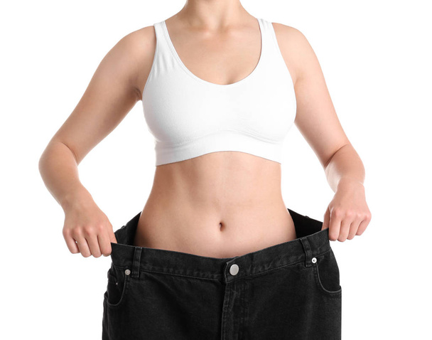 Mladá štíhlá žena v převracené džínách na bílém pozadí, šatna - Fotografie, Obrázek