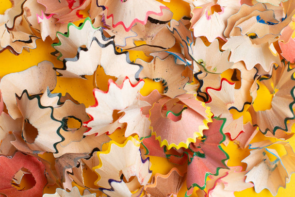 Colorful pencil shavings on yellow background. Back to school co - Photo, Image