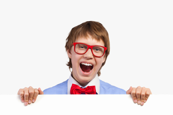 Boy in red glasses holding white square - Фото, изображение
