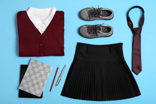 Flat lay composition with school uniform on blue background - Foto, afbeelding