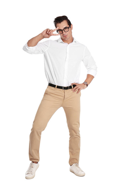 Handsome young man with glasses dancing on white background - Fotó, kép