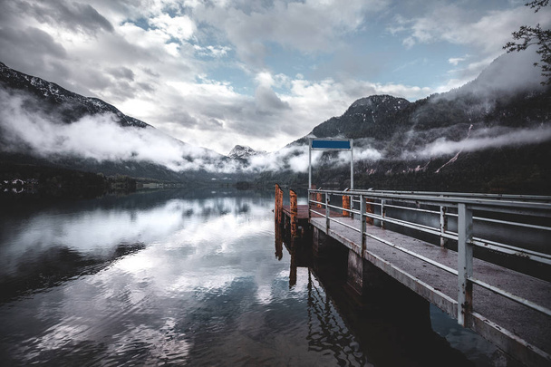 Increíble vista de los Alpes austríacos Montañas con niebla y reflejo en el lago
 - Foto, Imagen