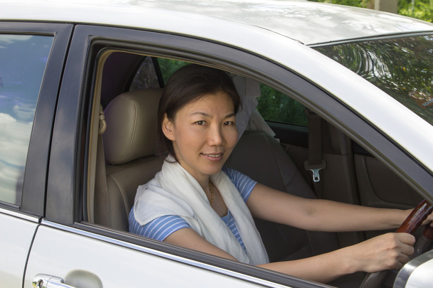 Hymyilevä nainen istuu autossa - Valokuva, kuva