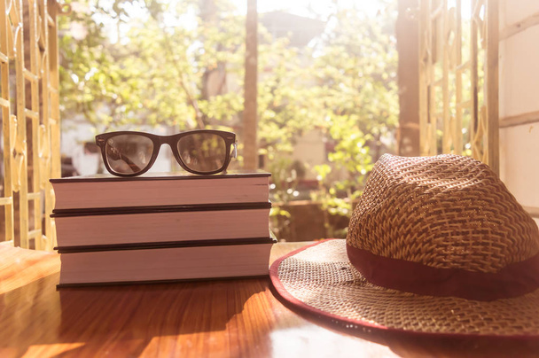 ストロー帽子付きの本とサングラスの正面面図。夏休み休暇背景コンセプト. - 写真・画像