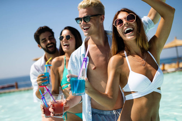 Group of friends together having fun at summer party and drinking cocktail - Photo, image