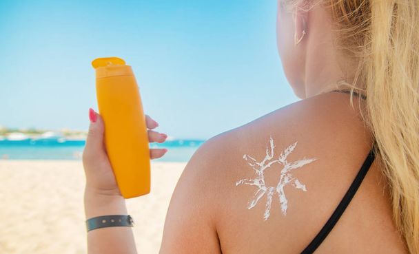 De meisjes op het strand dragen zonnebrandcrème op hun huid. Selectieve focus. - Foto, afbeelding