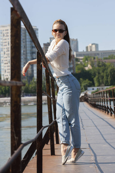 Young woman on the pier at the river. - Фото, зображення