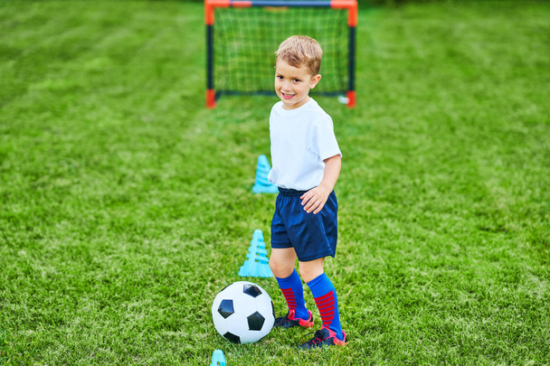 Petit garçon pratiquant le soccer en plein air
 - Photo, image