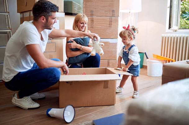 Young family after buying new house unpacking boxe - Foto, Bild
