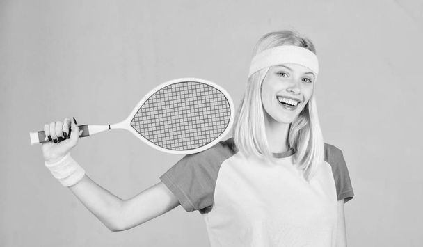 Athlete hold tennis racket in hand on grey background. Tennis sport and entertainment. Tennis club concept. Girl adorable blonde play tennis. Sport for maintaining health. Active leisure and hobby - Foto, Imagem