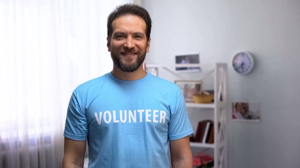 Middle aged male volunteer looking at camera, charity organization, caregiver - Foto, immagini