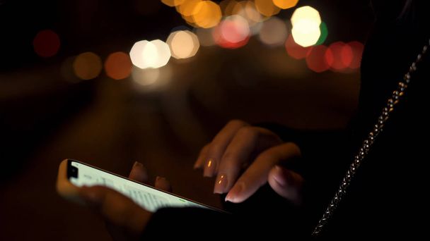 Lady chatting on phone, walking late night in illuminated city, dating friend - Photo, Image