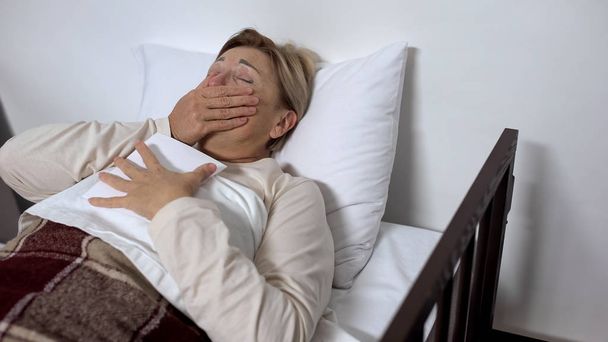 Crying sick woman hugging family photo, lying in hospital bed, valuable memories - Φωτογραφία, εικόνα