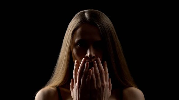 Τρομαγμένη γυναίκα που ανοίγει πρόσωπο με χέρια, θύμα βιασμού, έννοια κοινωνικής ανασφάλειας - Φωτογραφία, εικόνα