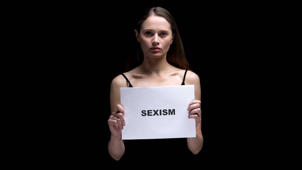 Woman showing sexism sign, protest against gender discrimination, human rights - Foto, imagen