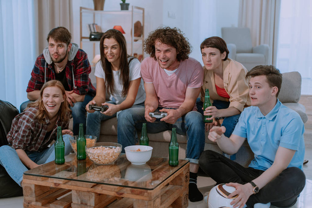 Ενθουσιασμένοι φίλοι που παίζουν βιντεοπαιχνίδια στο σπίτι - Φωτογραφία, εικόνα