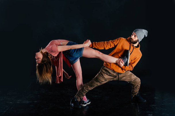 Пара танцующих современных танцев и выставляющих напоказ свои ноги
 - Фото, изображение