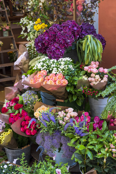 Una varietà di fiori in una mostra di strada di negozio di fiori, Italia. Bellissimi mazzi di fiori rosa, viola e bianchi. Composizione decorativa
. - Foto, immagini