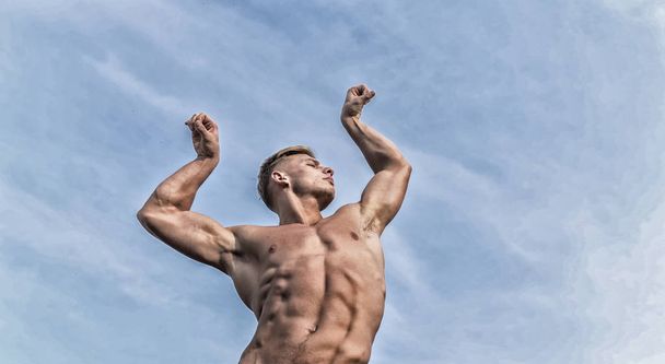 Man muscular athlete bodybuilder show muscles. Bodybuilder shape. Sexy torso attractive body. Strong muscles emphasize masculinity sexuality. Man muscular chest naked torso stand sky background - Foto, Bild