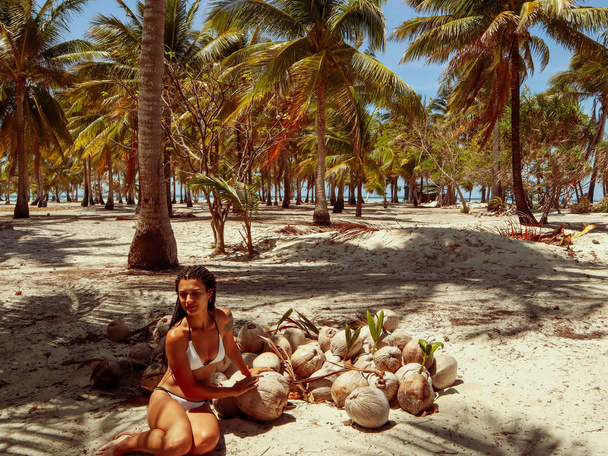 フィリピンのバラバク・パラワンのオノク島のヤシの木のジャングルでココナッツの殻を持つ女性 - 写真・画像