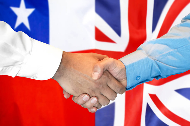kädenpuristus Chilessä ja Yhdistyneen kuningaskunnan lipun taustalla
. - Valokuva, kuva
