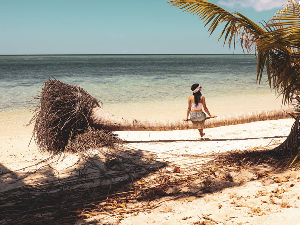 girl sitting on palm tree body like a bench in Onok island in Balabac in Palawan Philippines - Zdjęcie, obraz