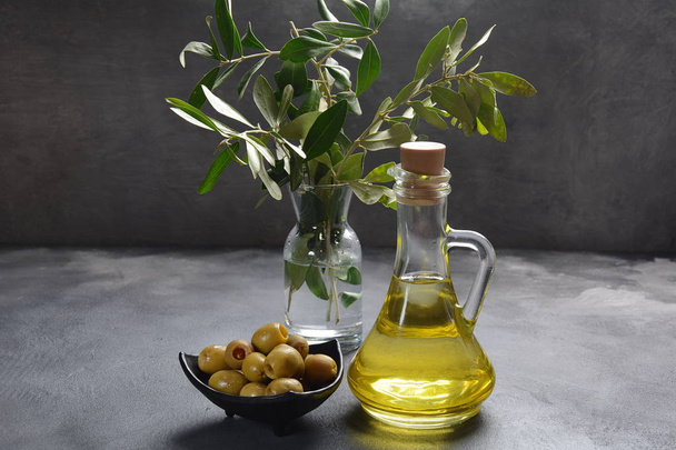 Extra panenský olivový olej, olivová větev a olivy na tmavém pozadí - Fotografie, Obrázek