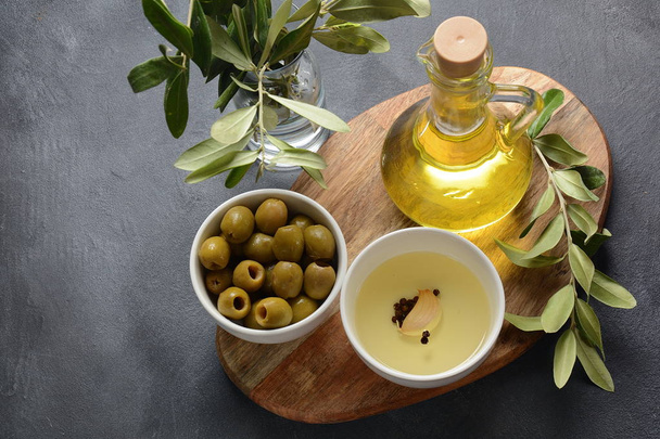 Extra virgin Olive oil , olive branch and olives on a dark background - Фото, изображение