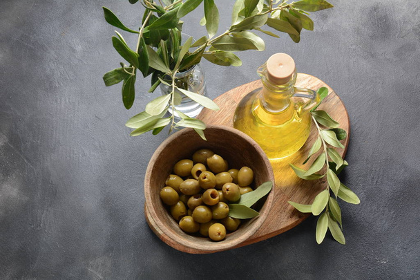 Extra virgin Olive oil , olive branch and olives on a dark background - Valokuva, kuva