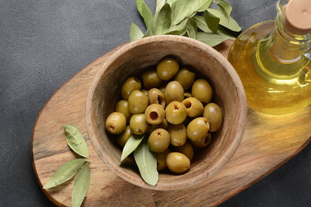 Extra virgin Olive oil , olive branch and olives on a dark background - Fotoğraf, Görsel