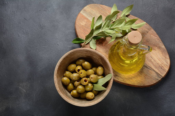 Extra virgin Olive oil , olive branch and olives on a dark background - Photo, Image