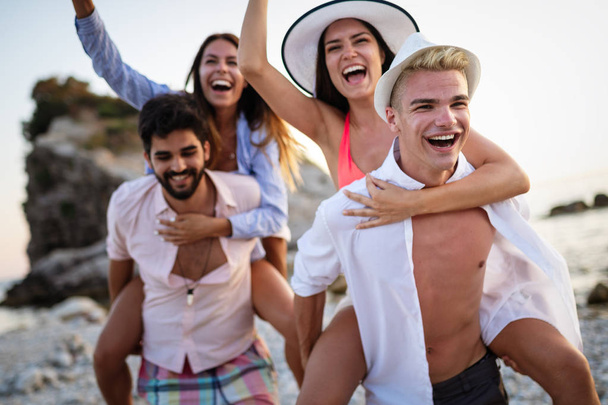 Skupina přátel, kteří se při dovolené baví na pláži - Fotografie, Obrázek