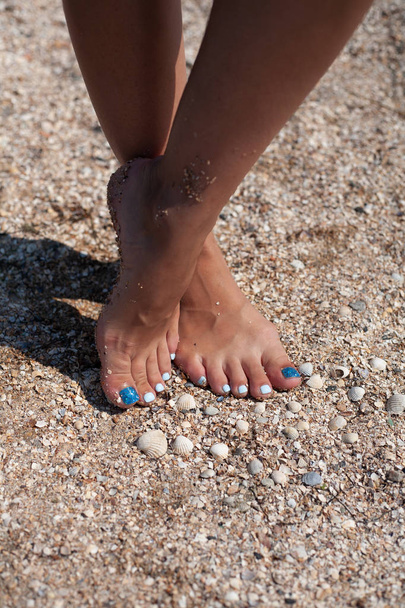 Όμορφο πεντικιούρ στη θάλασσα άμμο. Μπλε, καλοκαιρινό πεντικιούρ. Χαλαρώστε στην παραλία. - Φωτογραφία, εικόνα