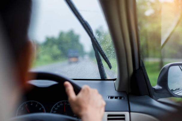 Szelektív hangsúly az ember vezetői egy autó eső cseppek a windsh - Fotó, kép