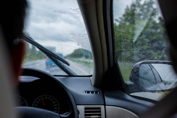 Selective focus to man driving a car with rain droplet on windsh - Fotó, kép