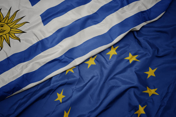 agitant drapeau coloré de l'union européenne et drapeau de uruguay
. - Photo, image