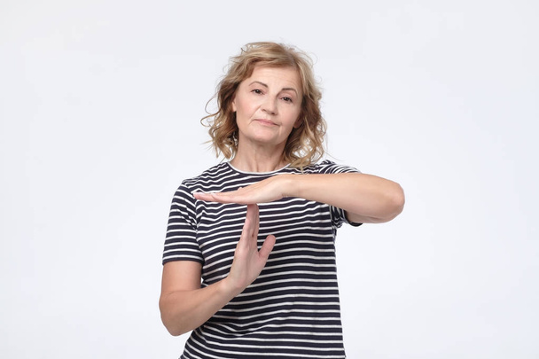 Serious worried mature woman showing time out sign - Photo, Image