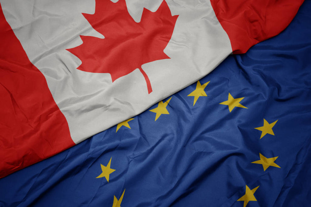 waving colorful flag of european union and flag of canada. - Foto, Imagem